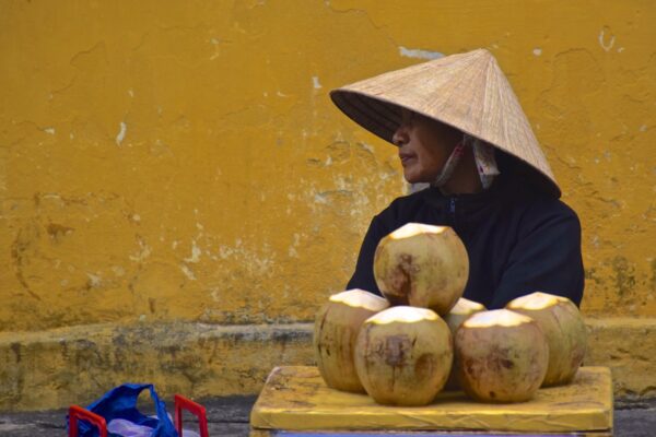Vendeuse de noix de coco dans une rue de Hoi An