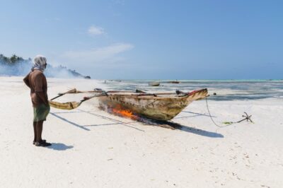 Plage de Pingwe : pêcheur qui nettoie son bateau